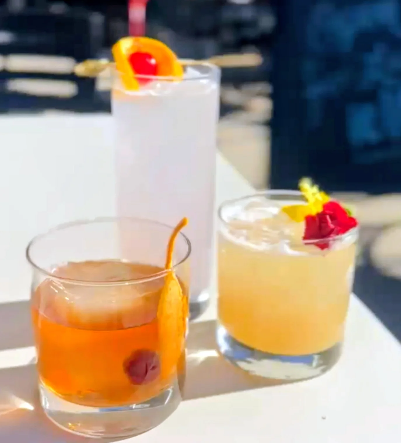 Three colorful cocktails on a table at a bar