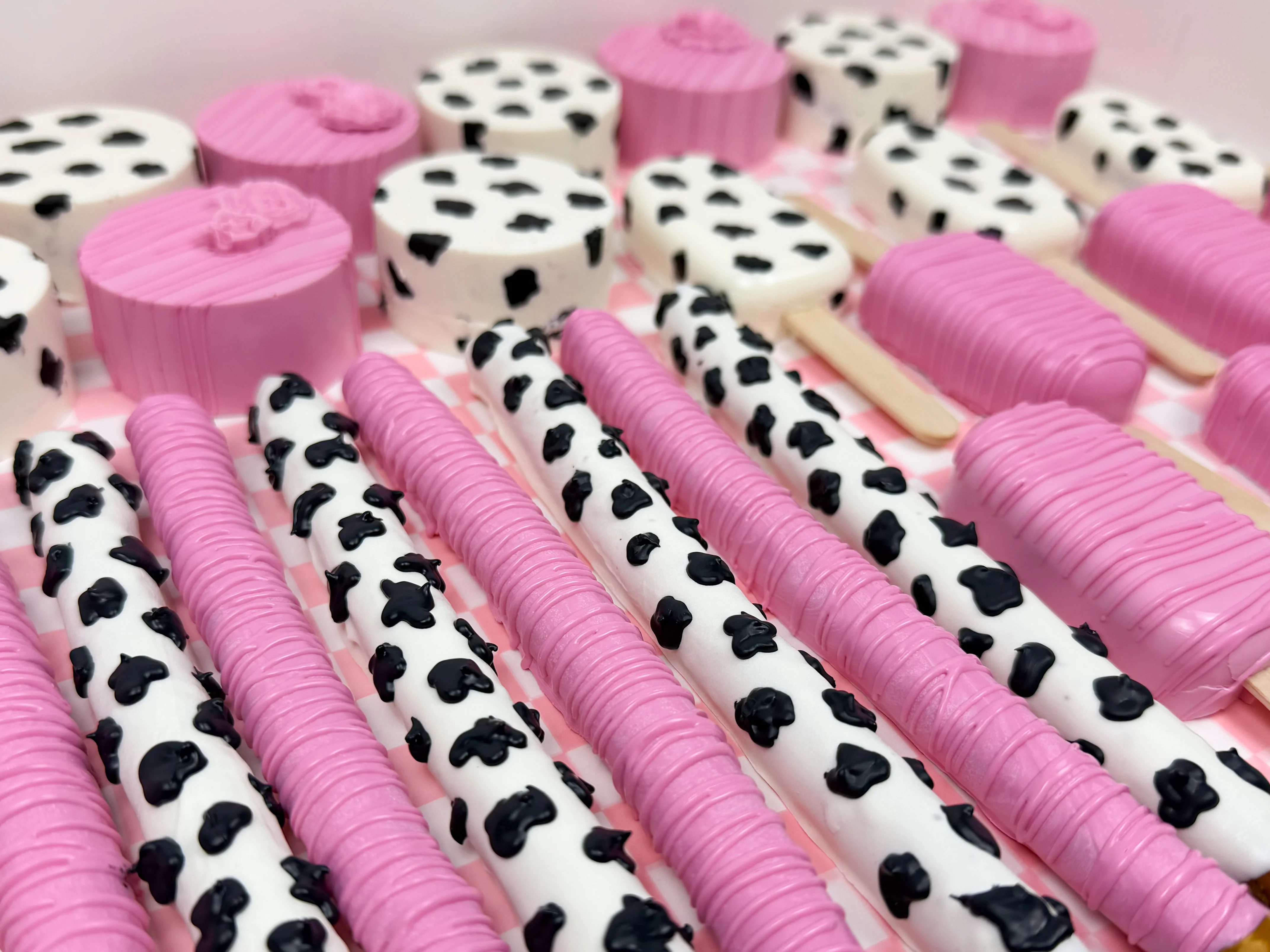 Colorful dessert display with pink and black spotted treats.