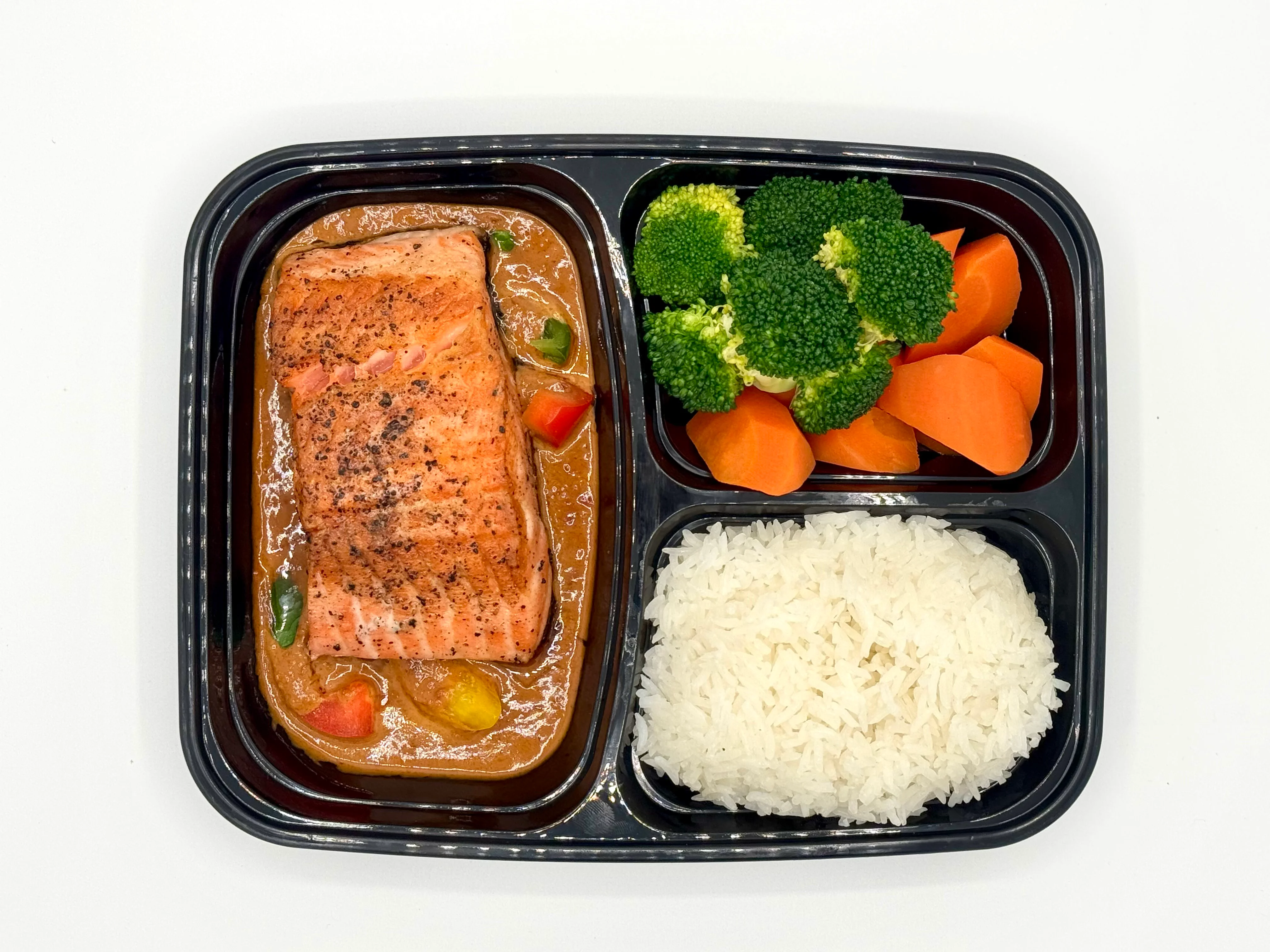 Grilled salmon with rice and vegetables in a meal prep container