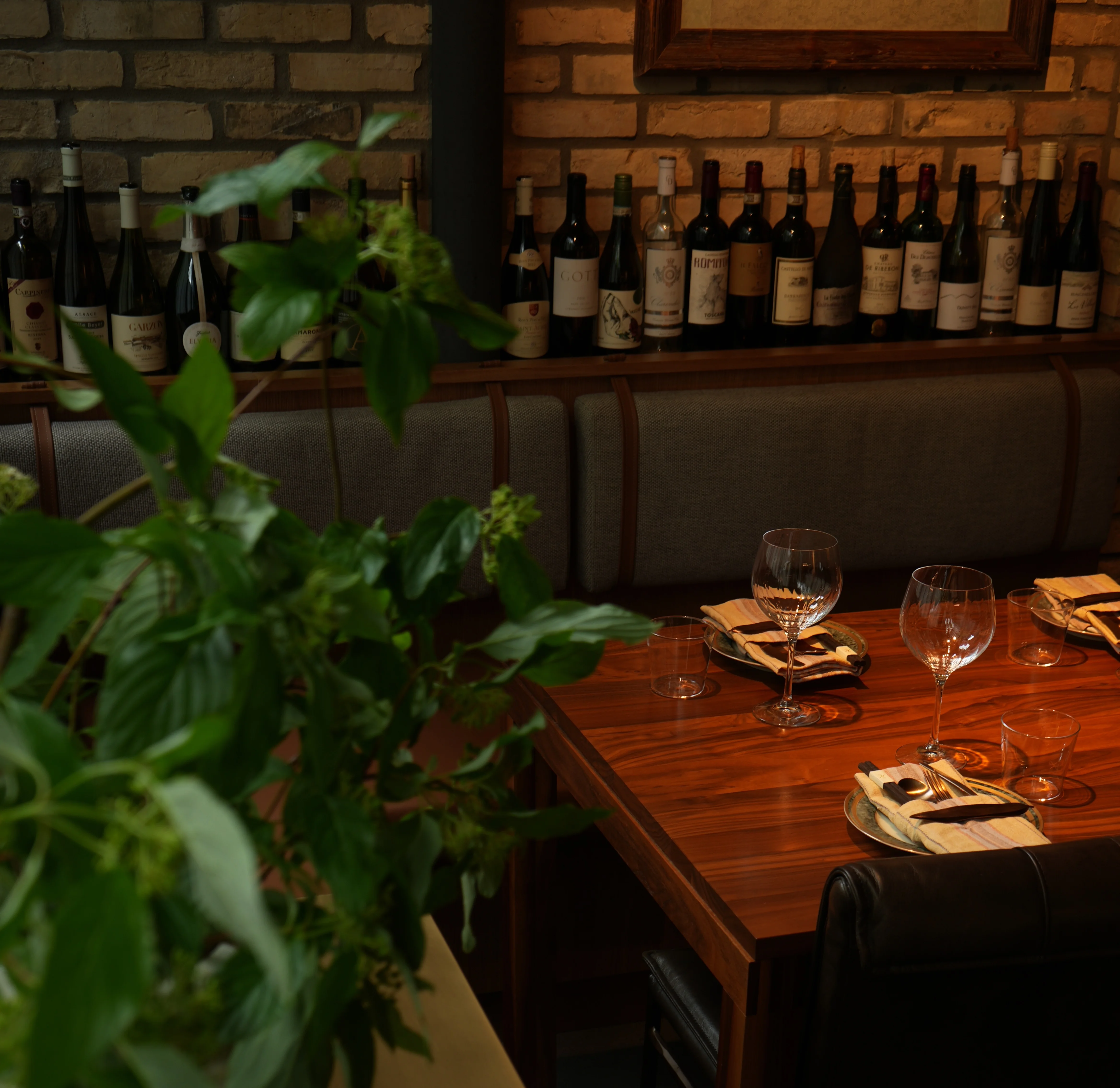 Cozy restaurant interior with wooden table and wine bottles on display