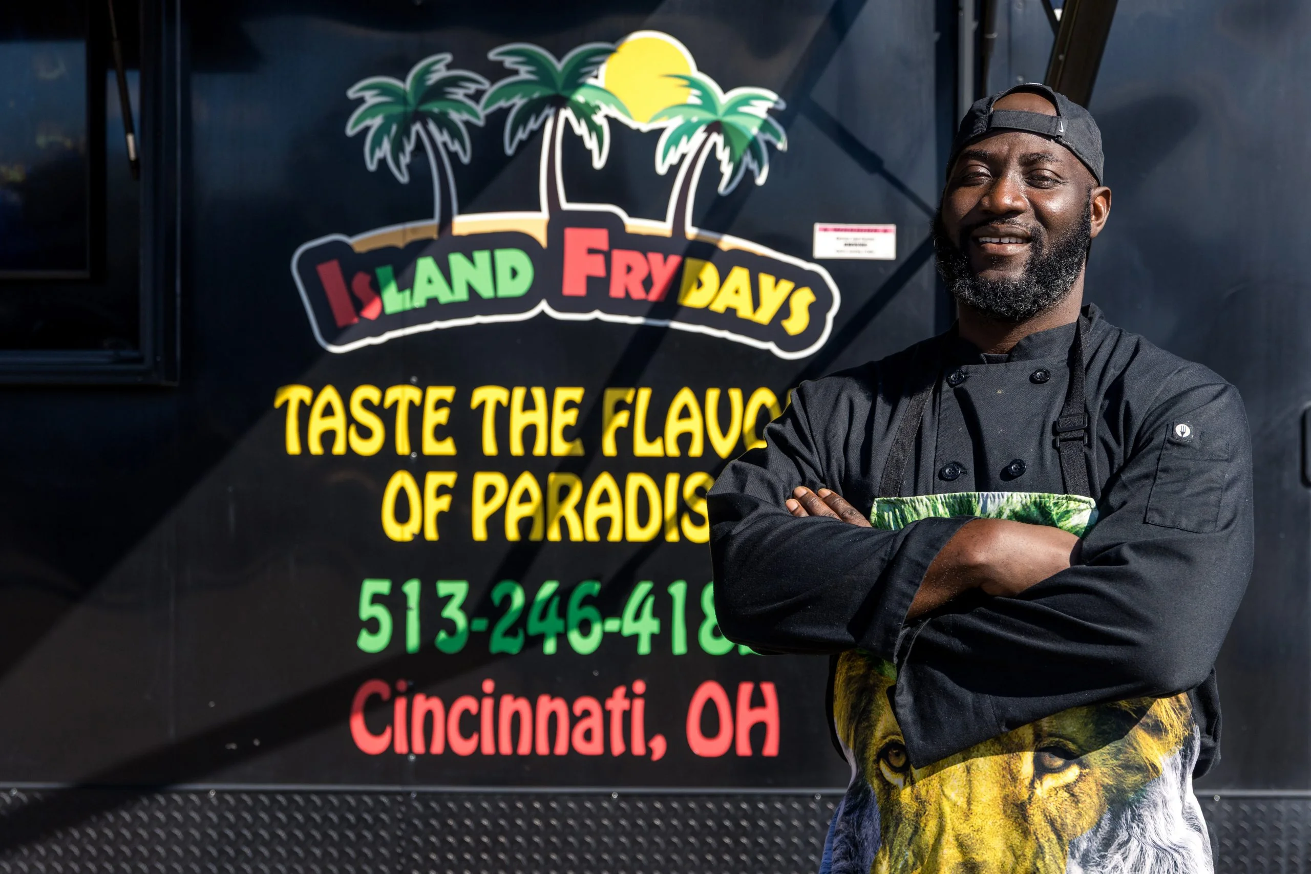 Chef in front of food truck promoting Caribbean cuisine
