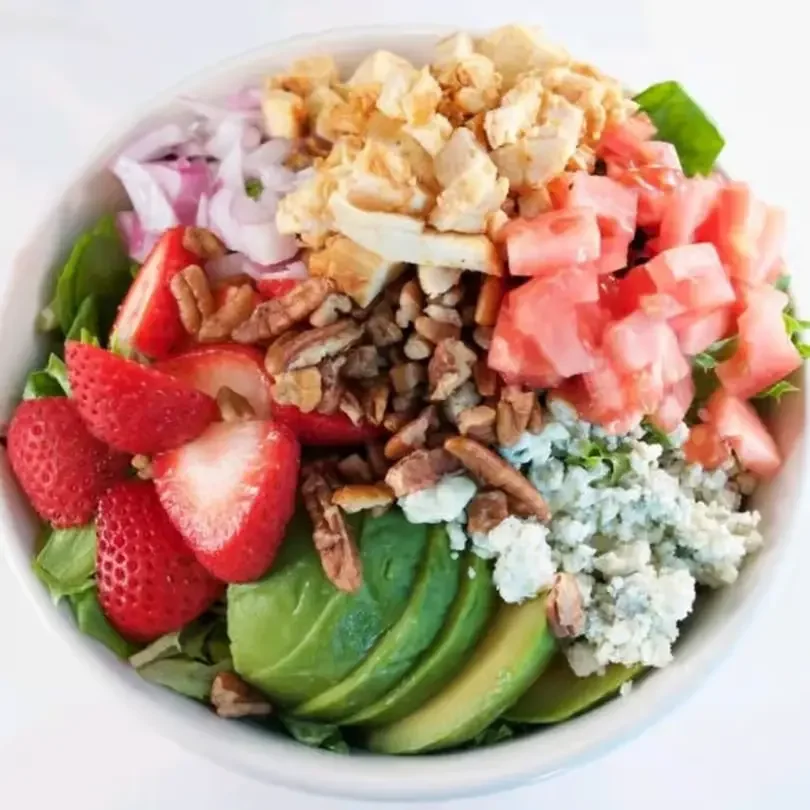 Fresh garden salad at Moonlite Diner with avocado, strawberries, tomatoes, hard-boiled eggs, blue cheese, pecans, and mixed greens.