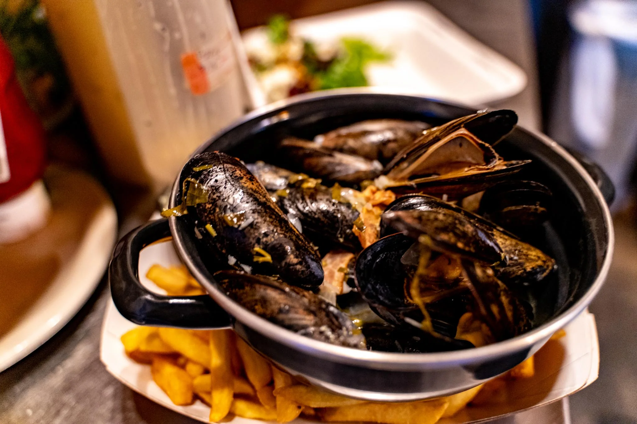 Mussels served in a pot with fries, a classic Belgian dish
