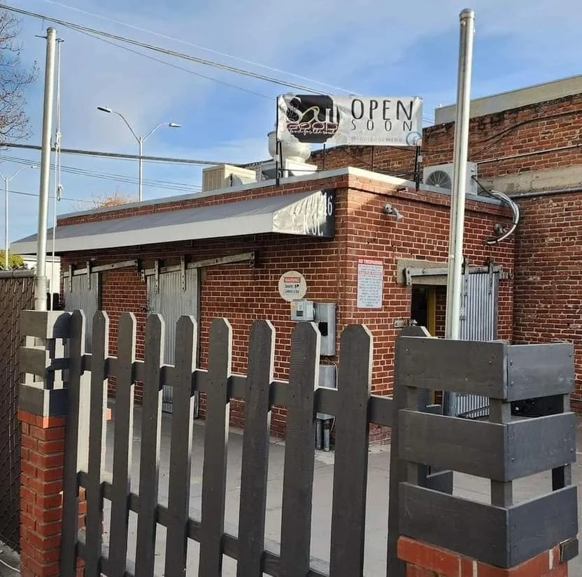 Exterior view of a restaurant with a sign announcing "Open Soon"