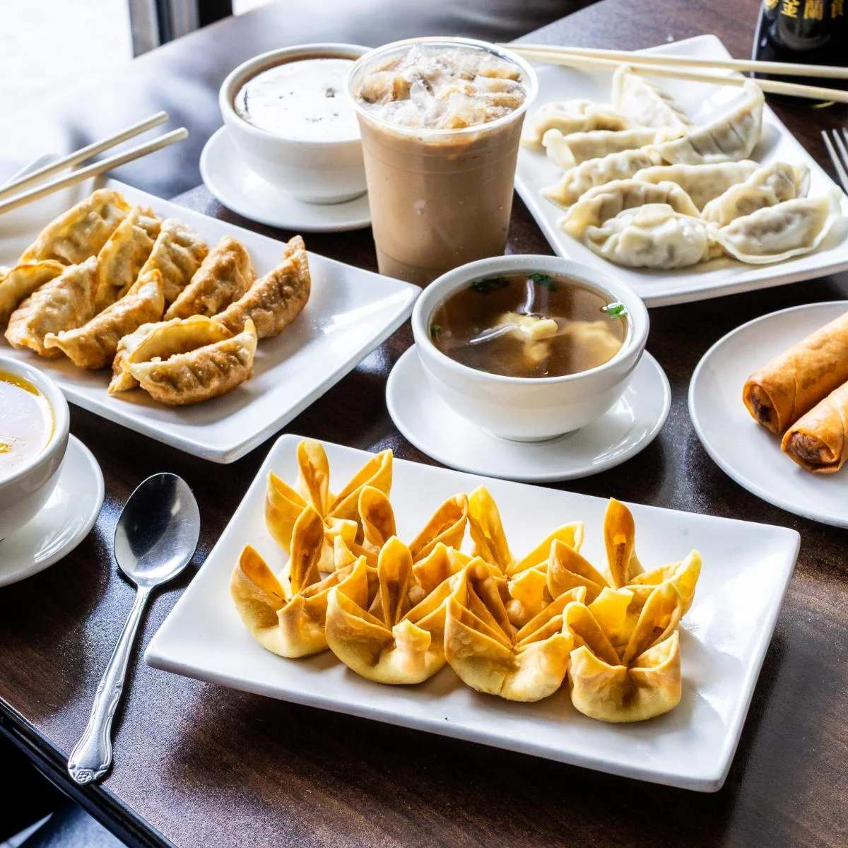 Assorted Chinese dumplings and spring rolls on a wooden table