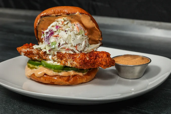 Spicy chicken sandwich with lettuce and sauce on a toasted bun