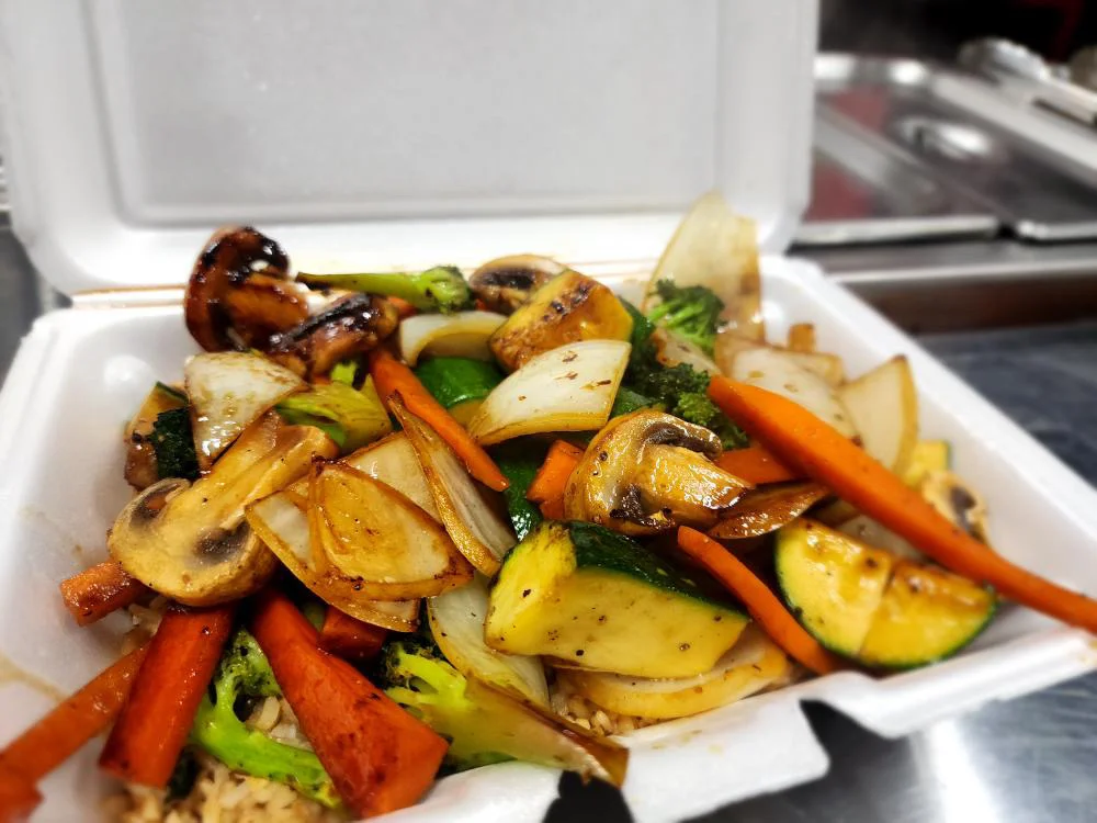 Stir-fried vegetable medley in a takeout container