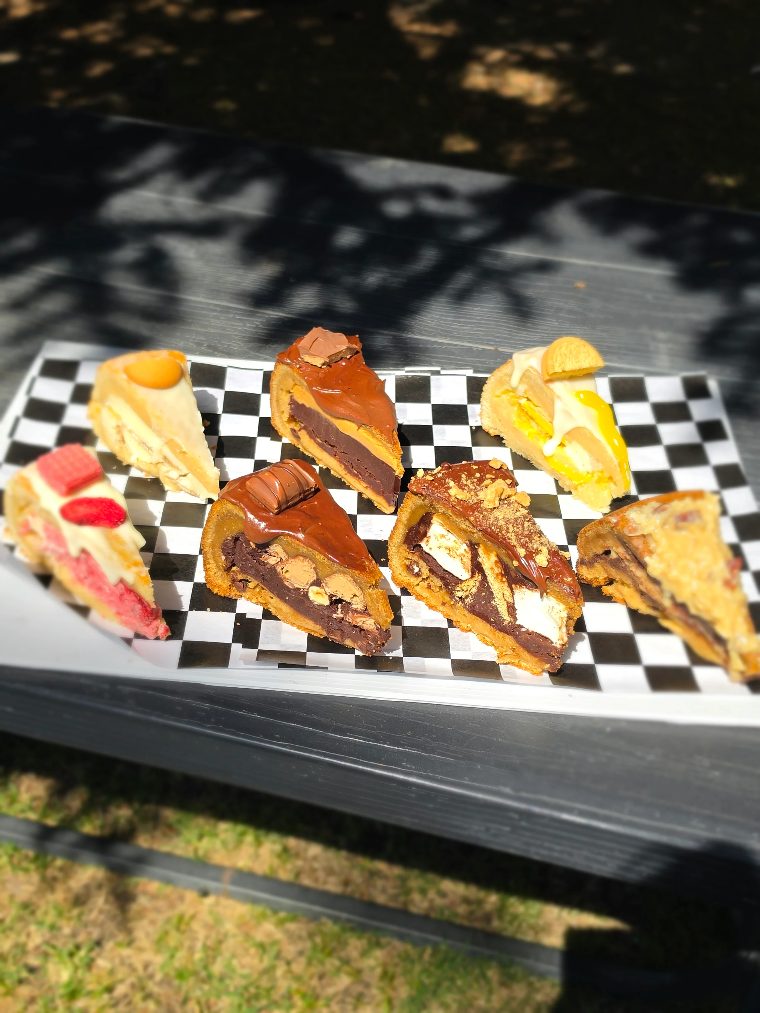 Assorted gourmet cheesecake slices on a checkered platter