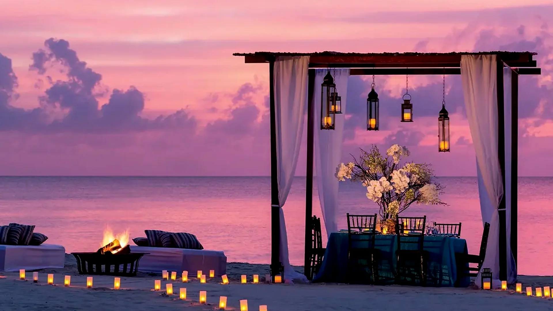 Romantic beach dining setup at sunset