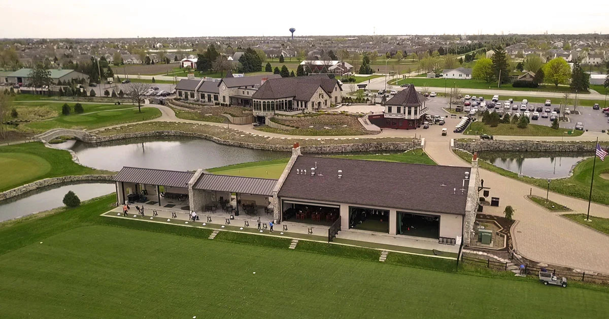 Aerial view of a golf course clubhouse and surrounding landscape