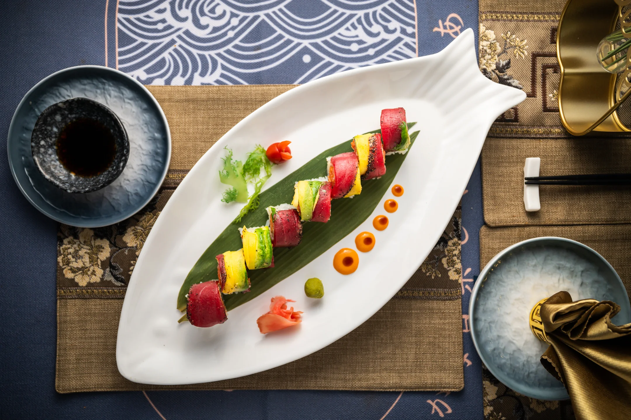 Colorful sushi platter with assorted rolls on a decorative leaf