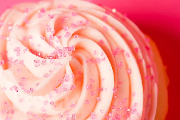 Delicious pink frosted cupcake with sprinkles