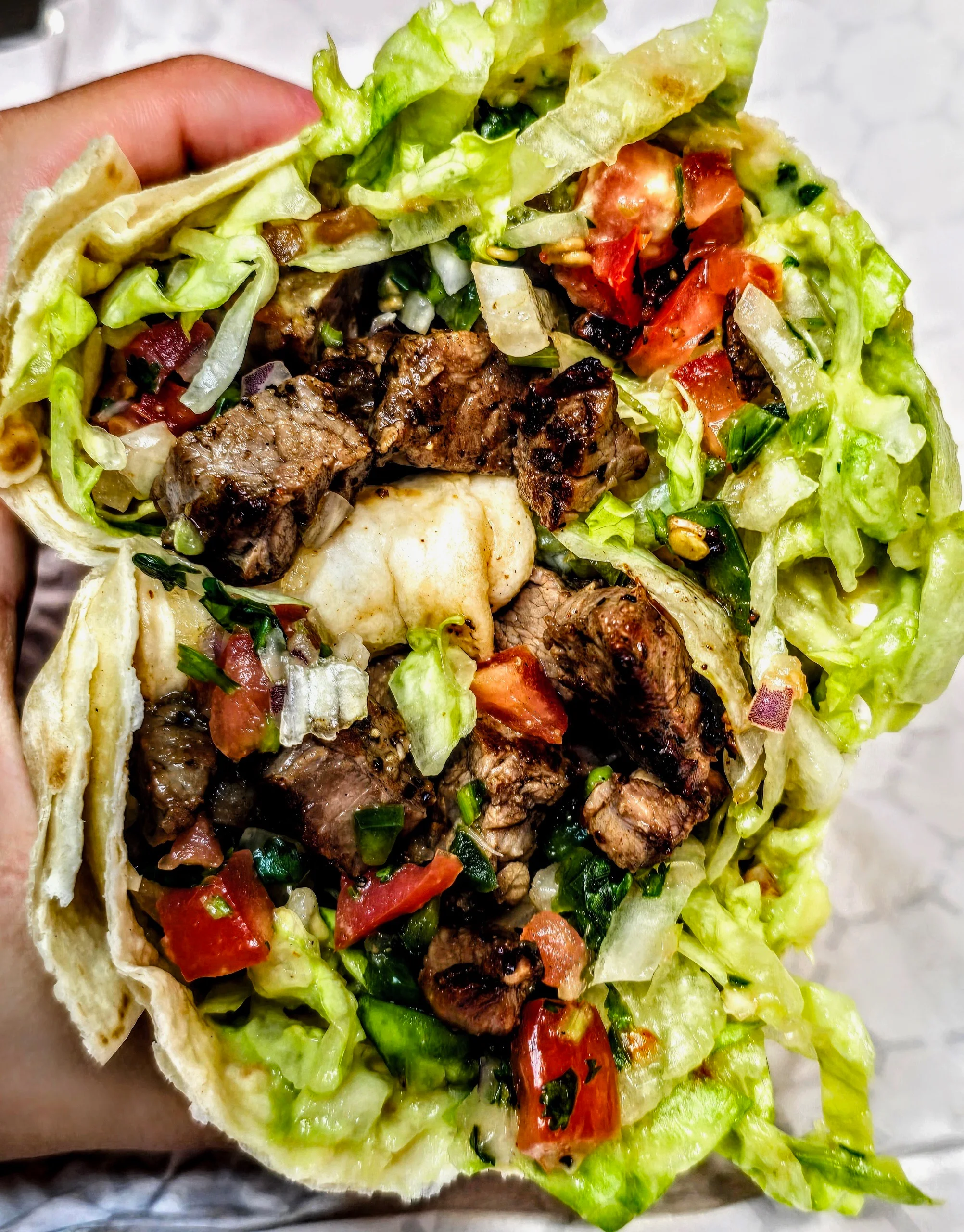 Delicious burrito filled with fresh ingredients on a wooden table.