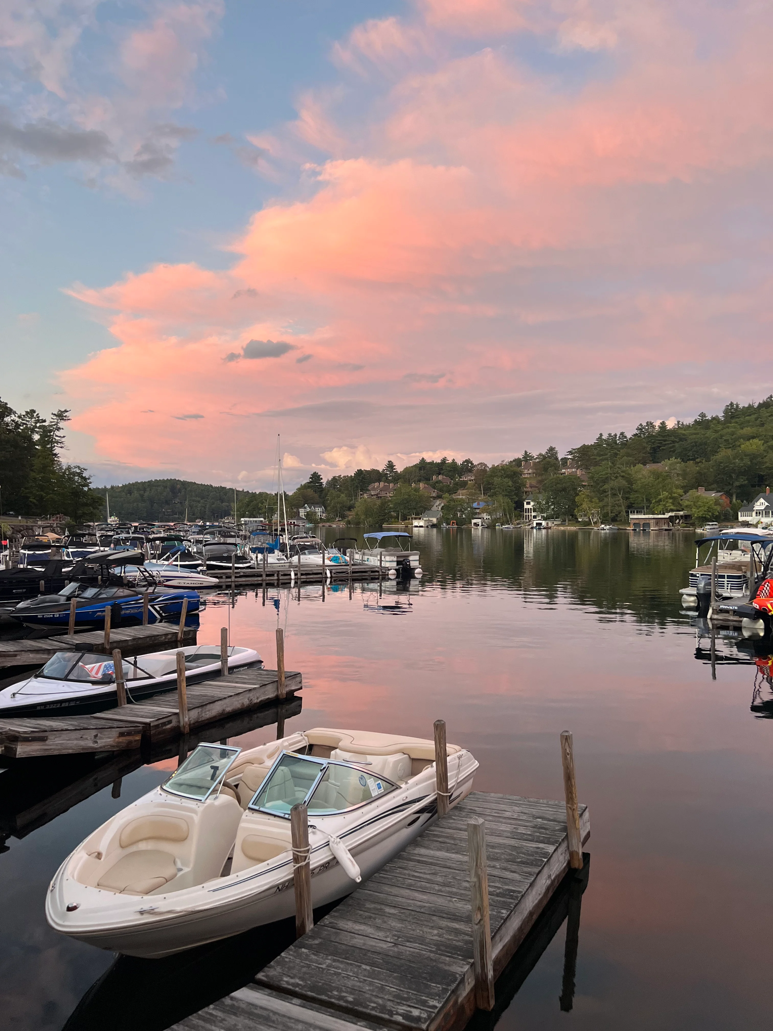 Scenic lake view at sunset with boats and colorful clouds