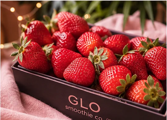 Fresh strawberries in black boxes at a market