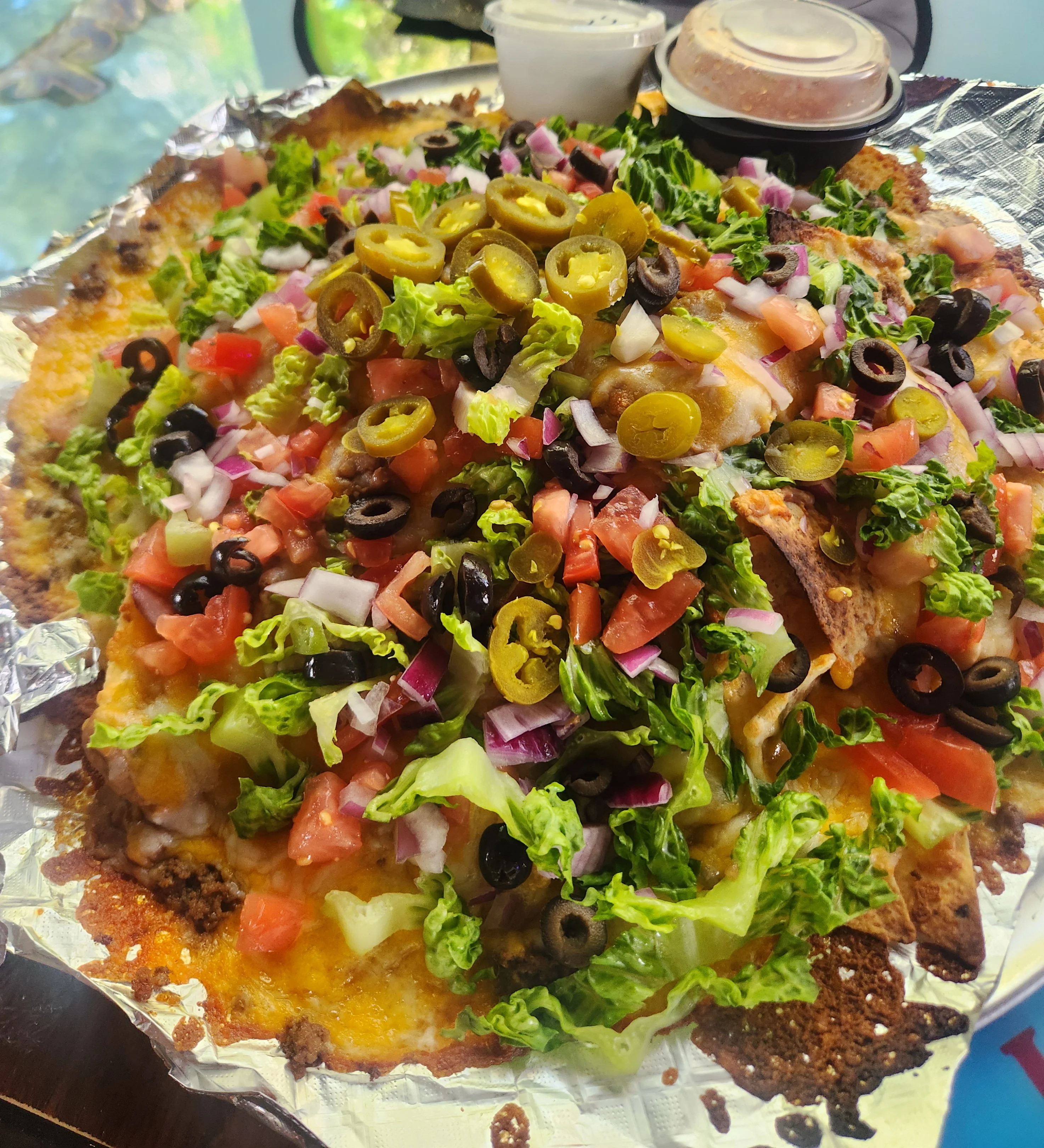 Loaded nachos topped with fresh vegetables and jalapeños