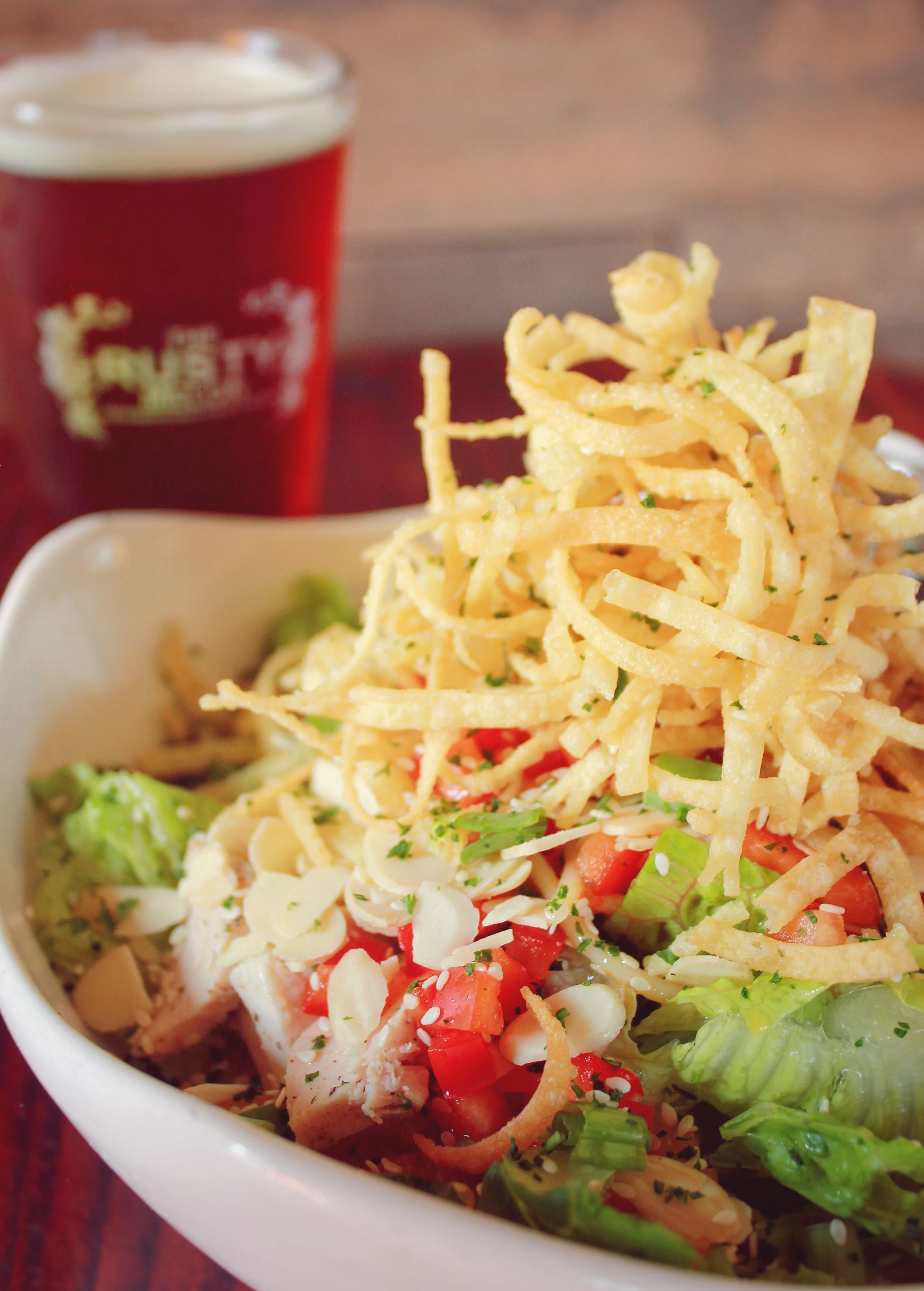 Crispy chicken salad with tortilla strips and craft beer
