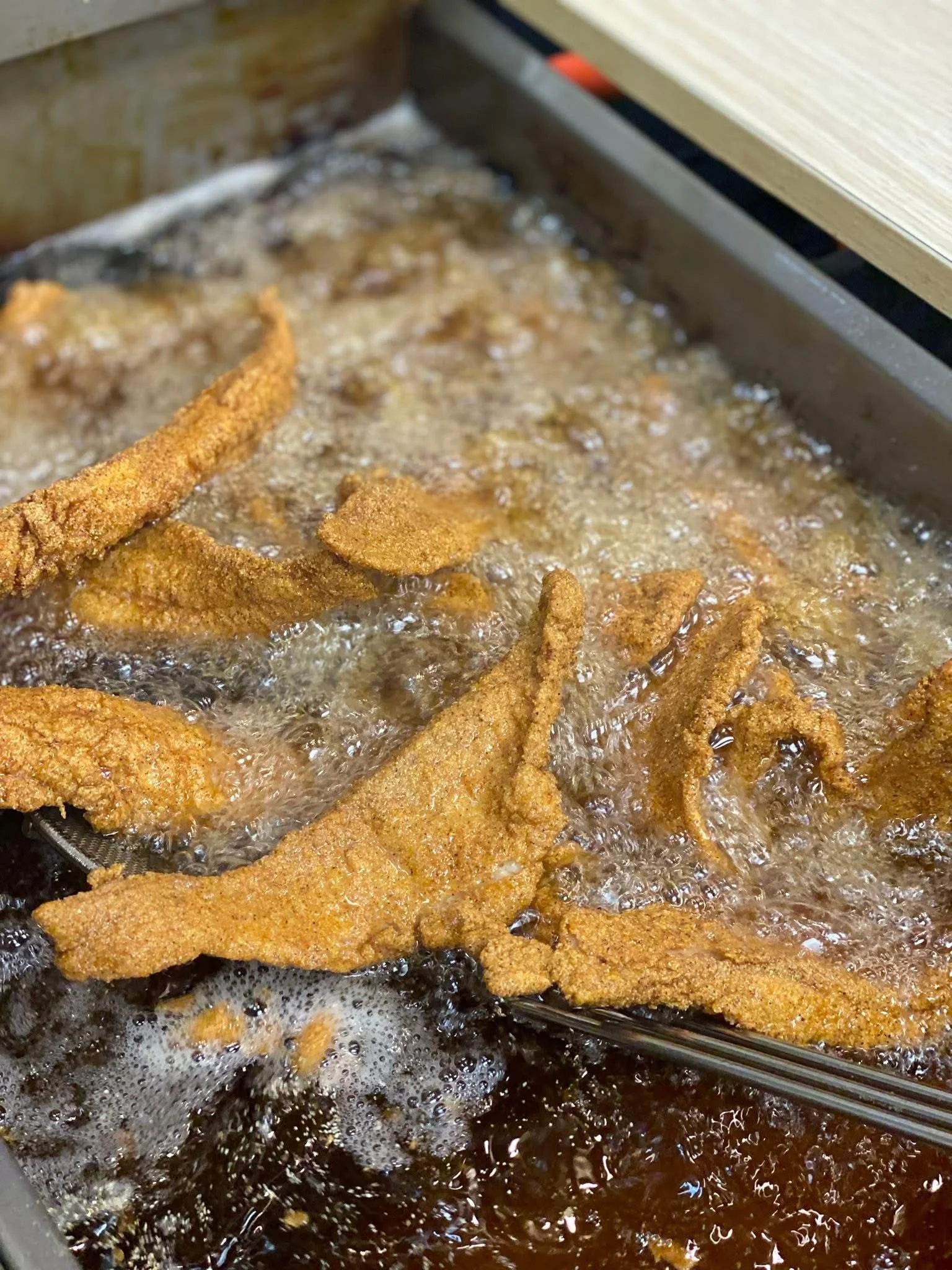 Crispy fried catfish fillets in hot oil