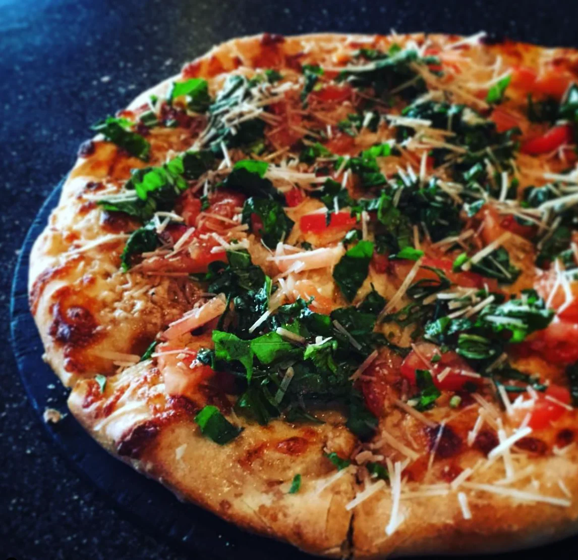 Freshly baked spinach and tomato pizza