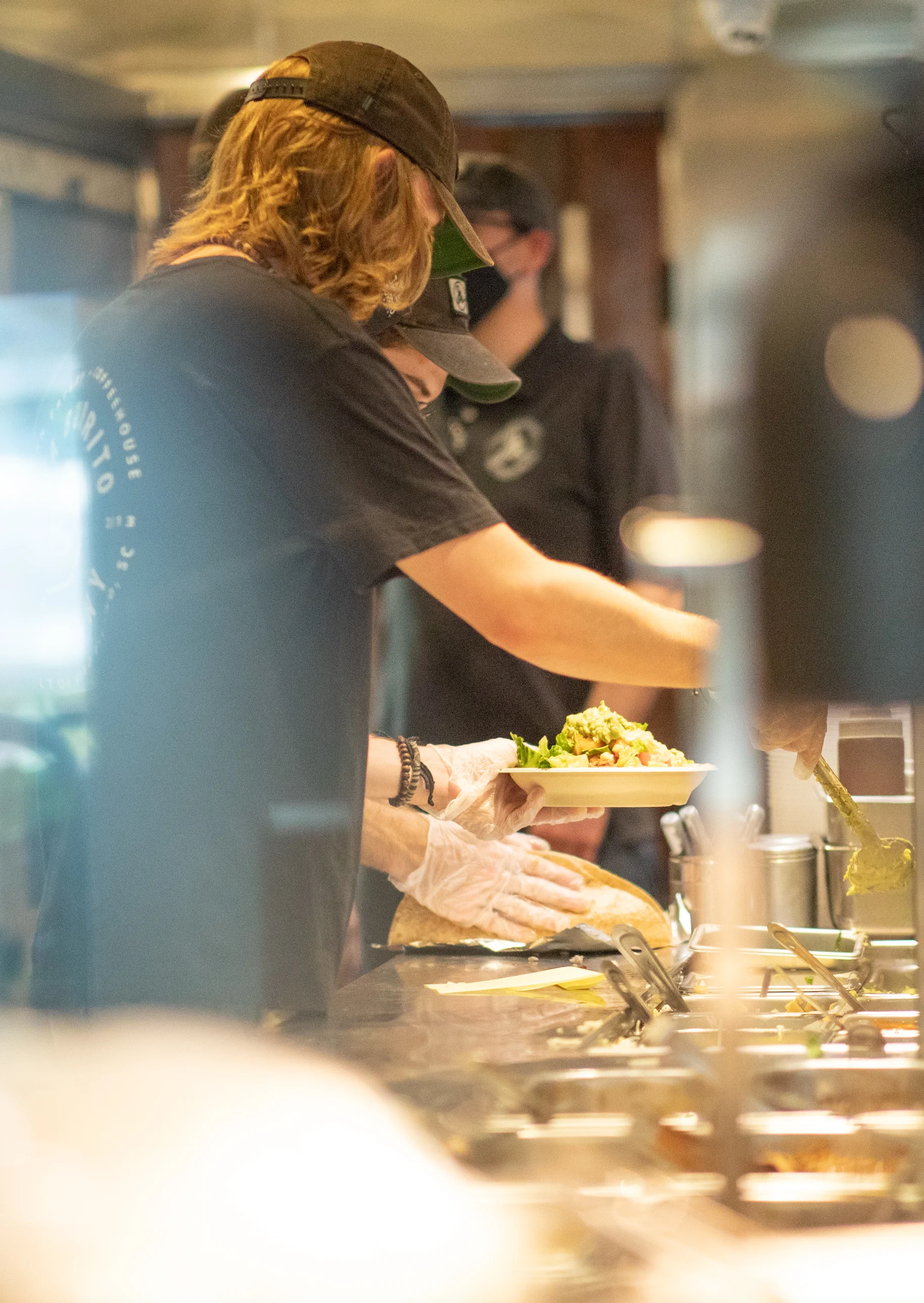 Staff preparing fresh salads in a vibrant restaurant kitchen