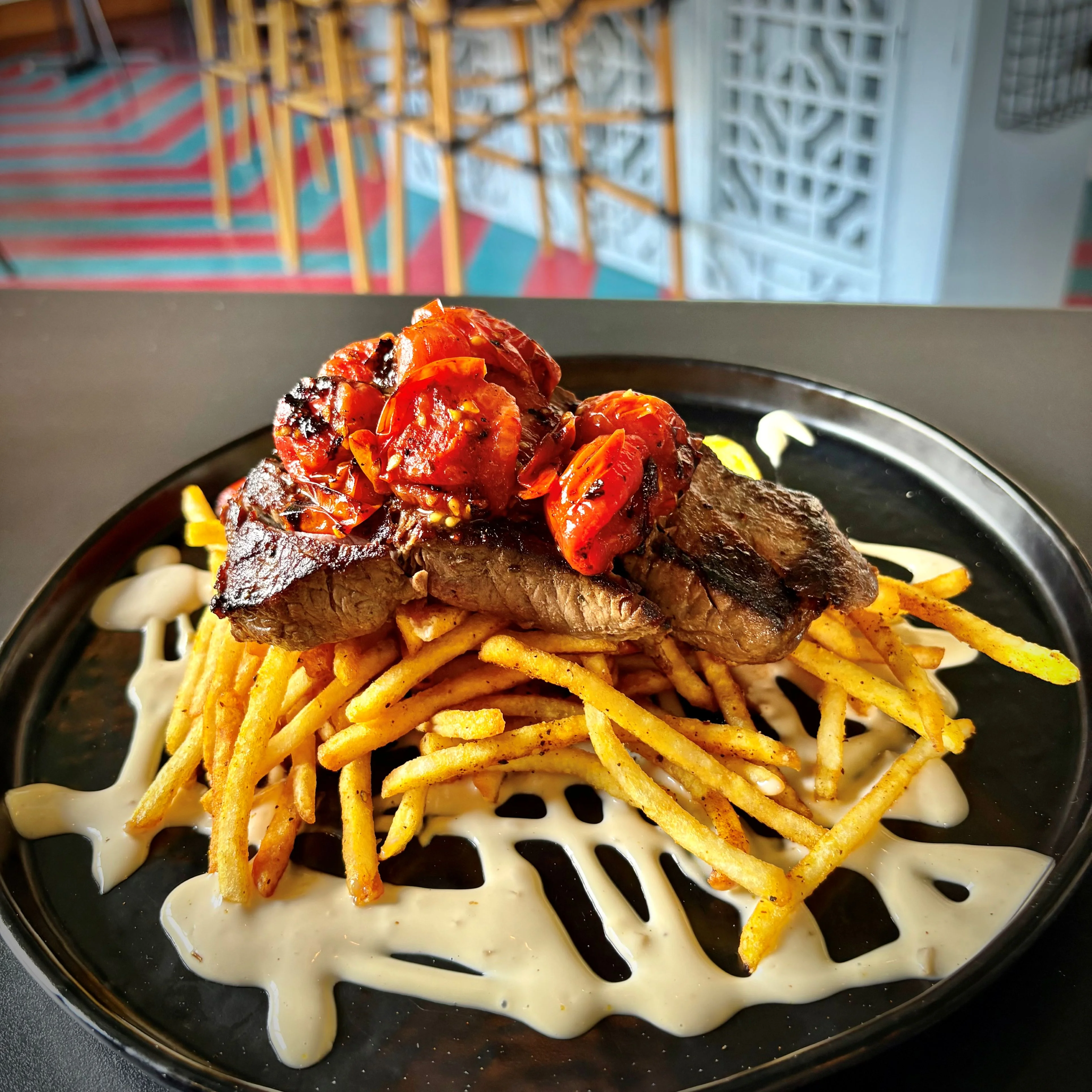 Grilled steak with roasted tomatoes on fries