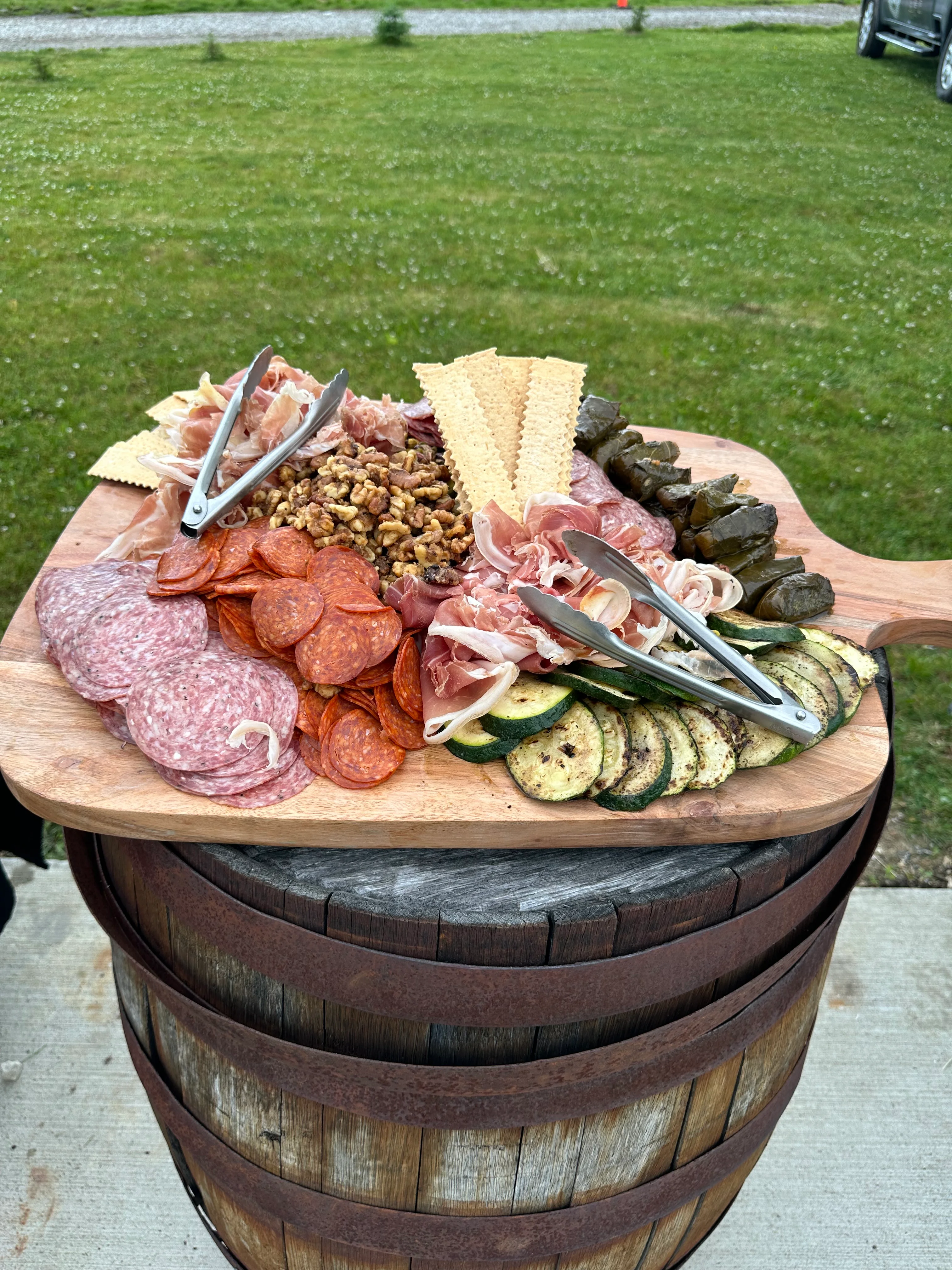 A charcuterie board displaying an assortment of meats, cheeses, nuts, and crackers, arranged on a wooden cutting board.