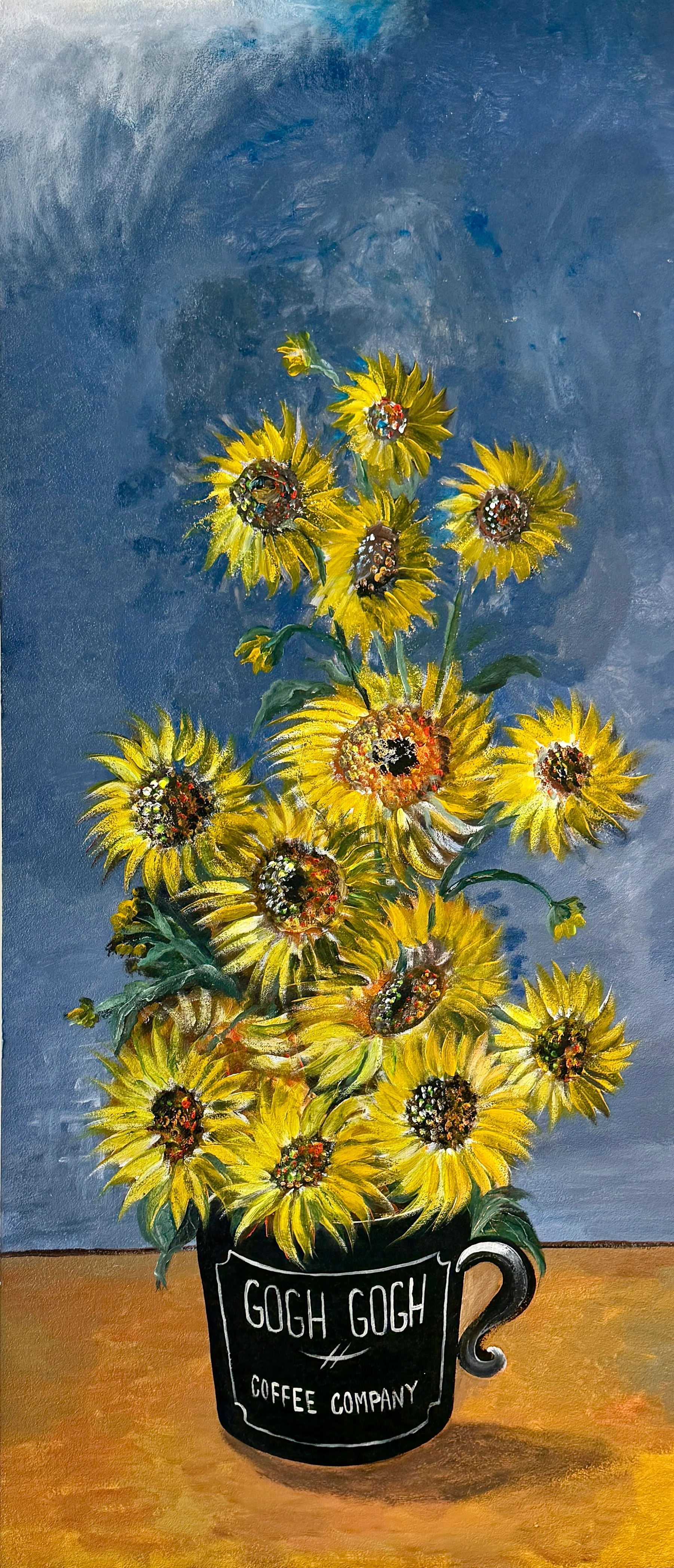 A ceramic mug filled with a bouquet of bright sunflowers against a textured blue background. The mug displays the words 'Coffee Company'.