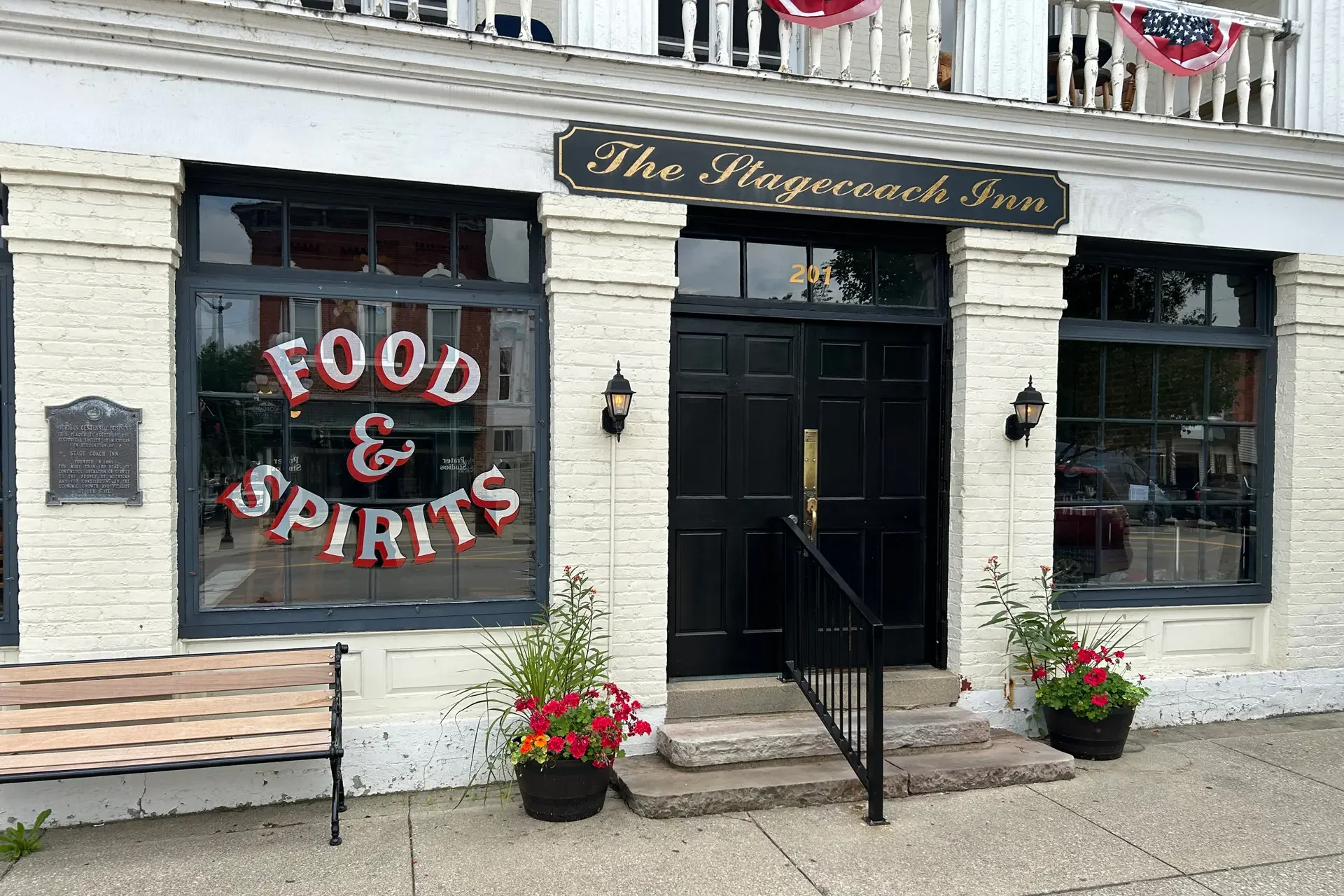 Exterior view of The Stagecoach Inn with sign and flowers