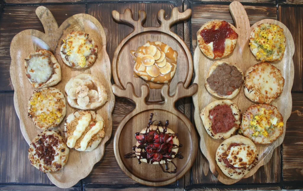 Assorted mini pizzas on wooden platters