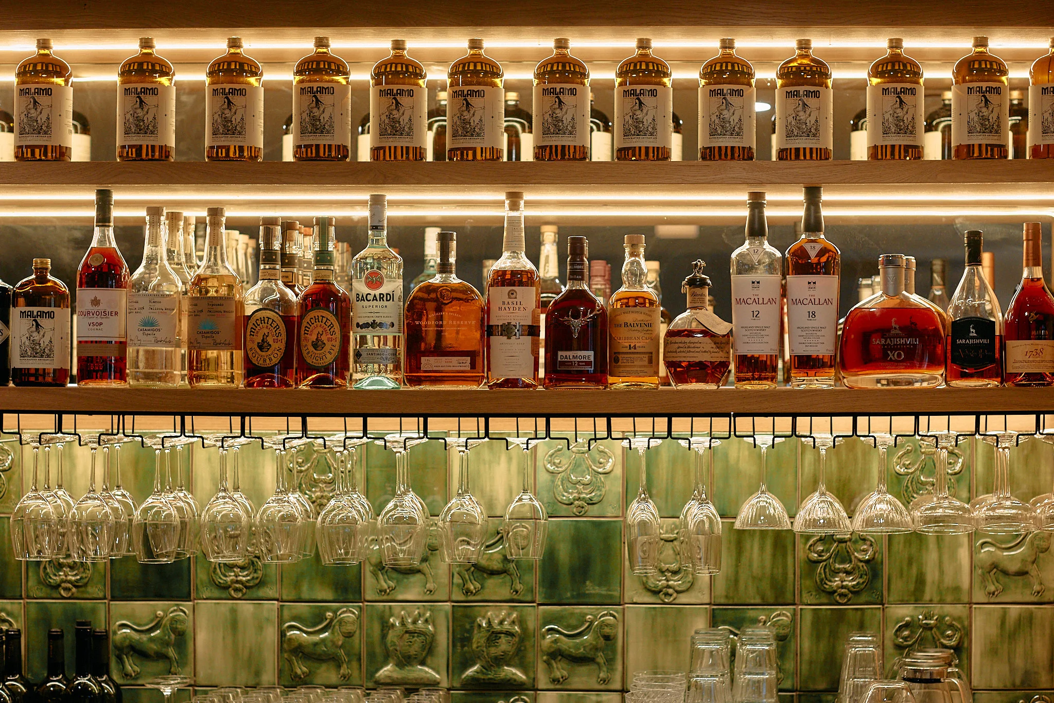 Well-stocked bar with various spirits and glassware
