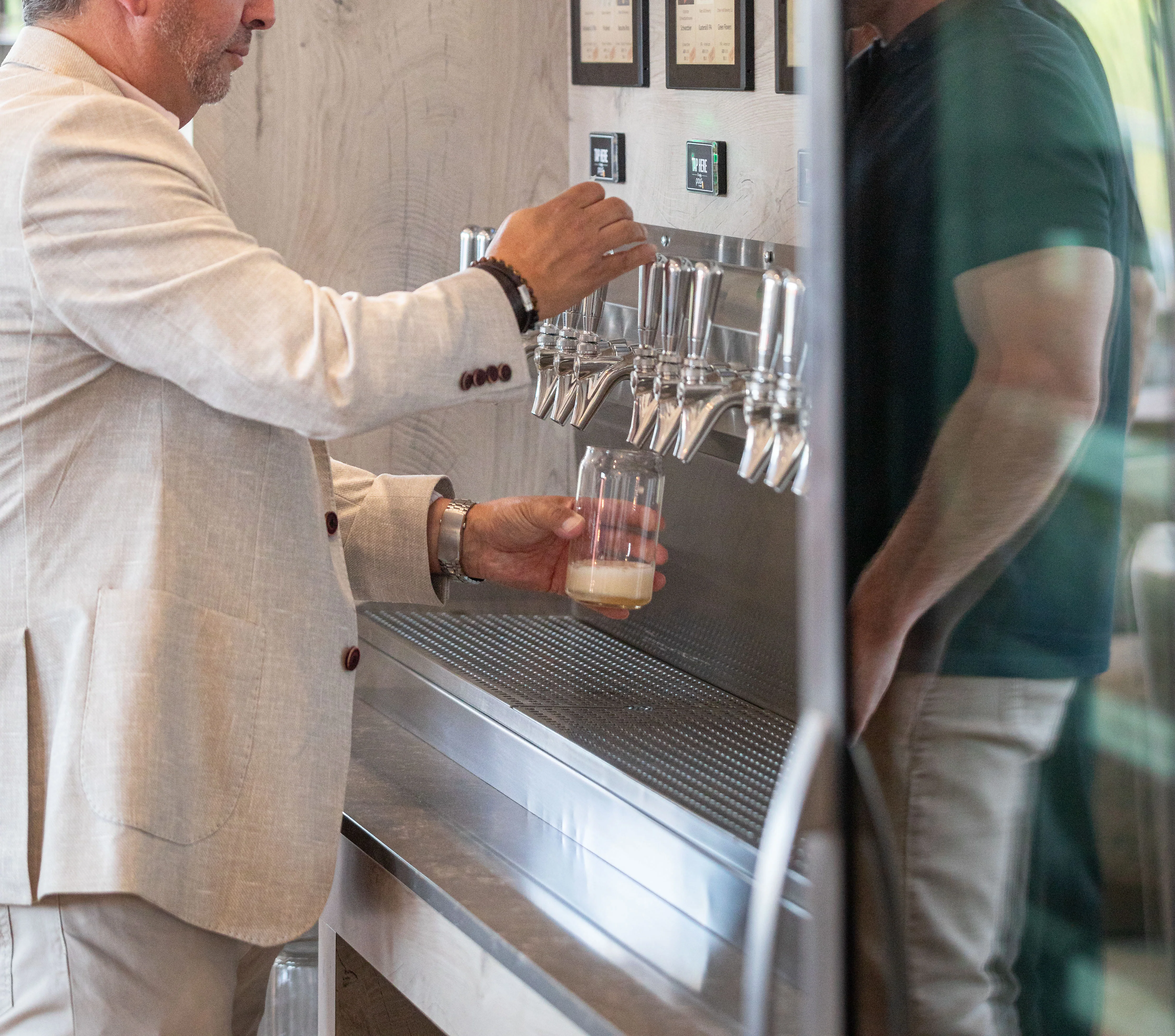 Customer pouring a drink at a modern beverage tap station