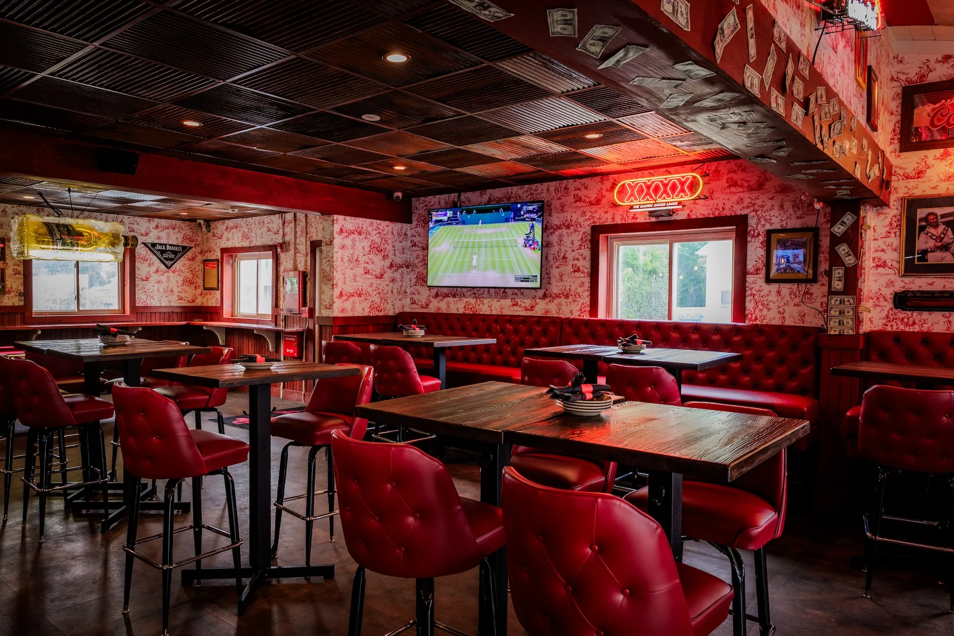 Cozy restaurant interior with red seating and sports TV