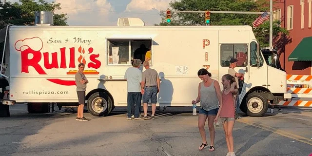 A colorful food truck parked, showcasing a variety of delicious food options.