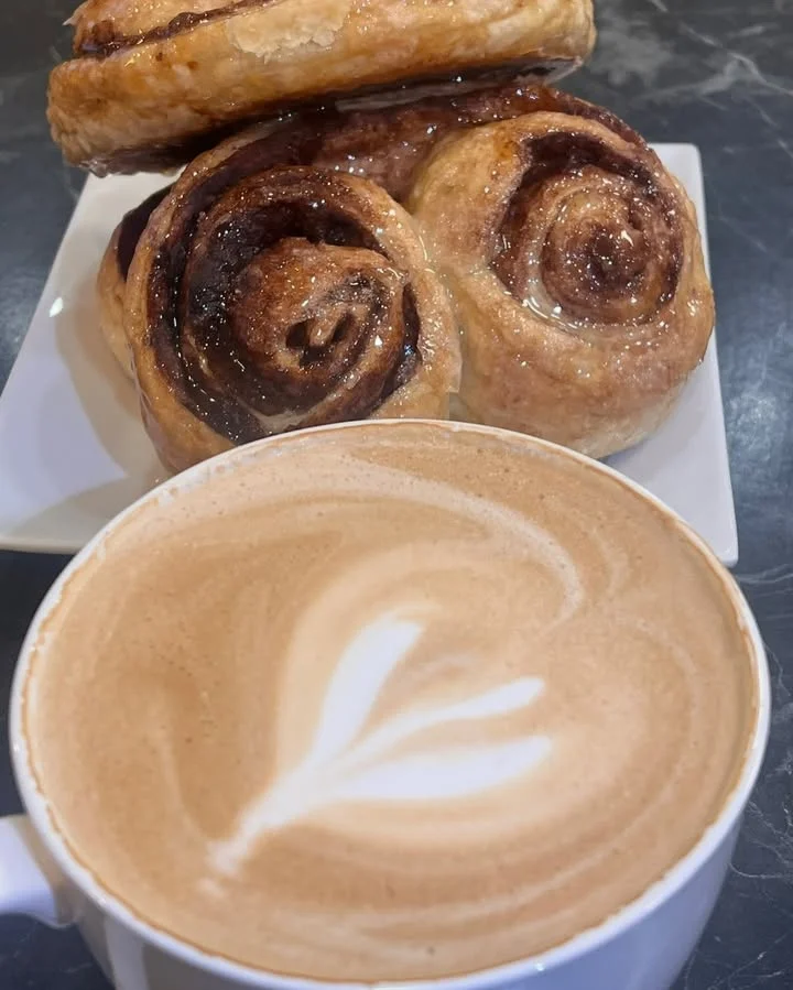 Freshly baked cinnamon rolls with latte art