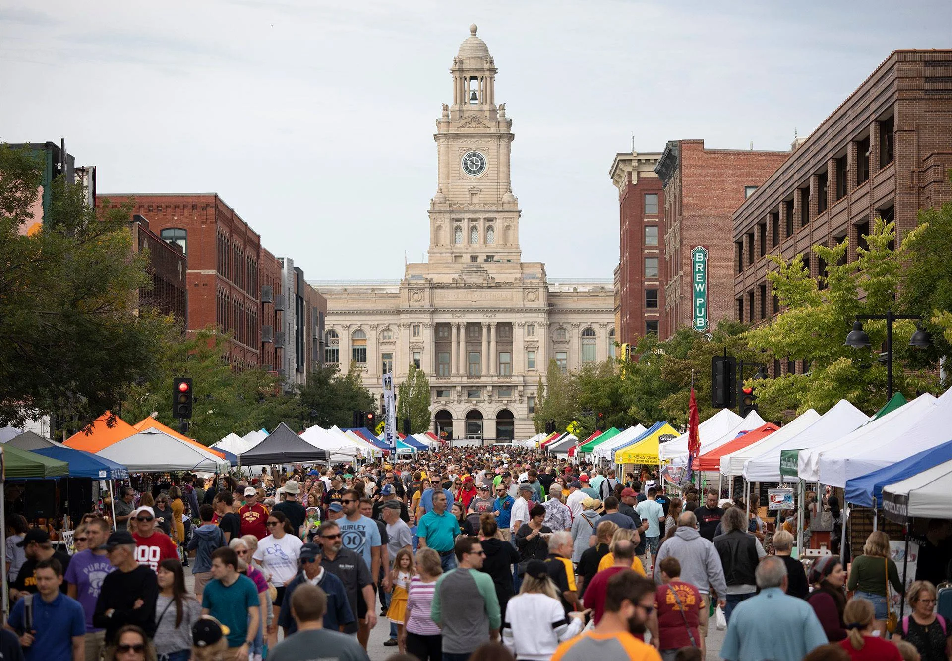 Busy street festival with food stalls and historic buildings