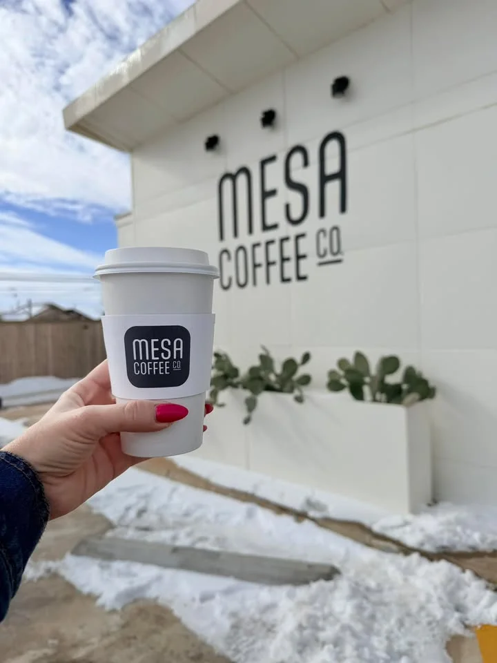 Coffee cup in front of Mesa Coffee Co. with snowy landscape