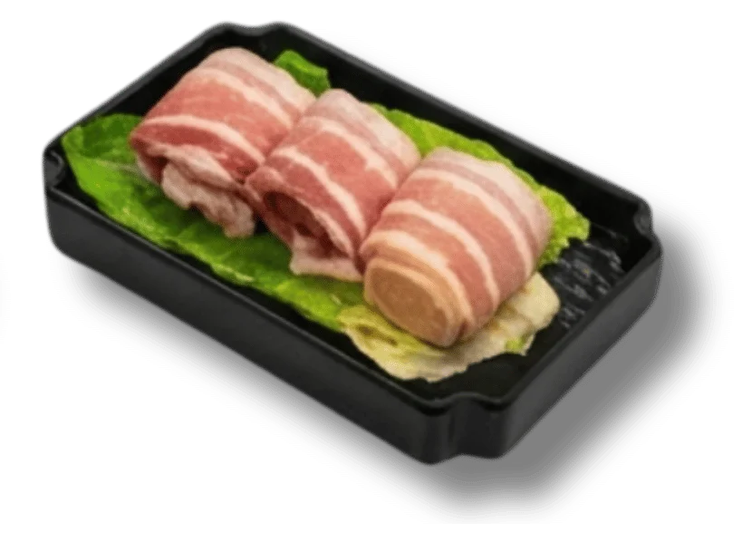 Three pieces of rolled bacon on lettuce in a black tray.