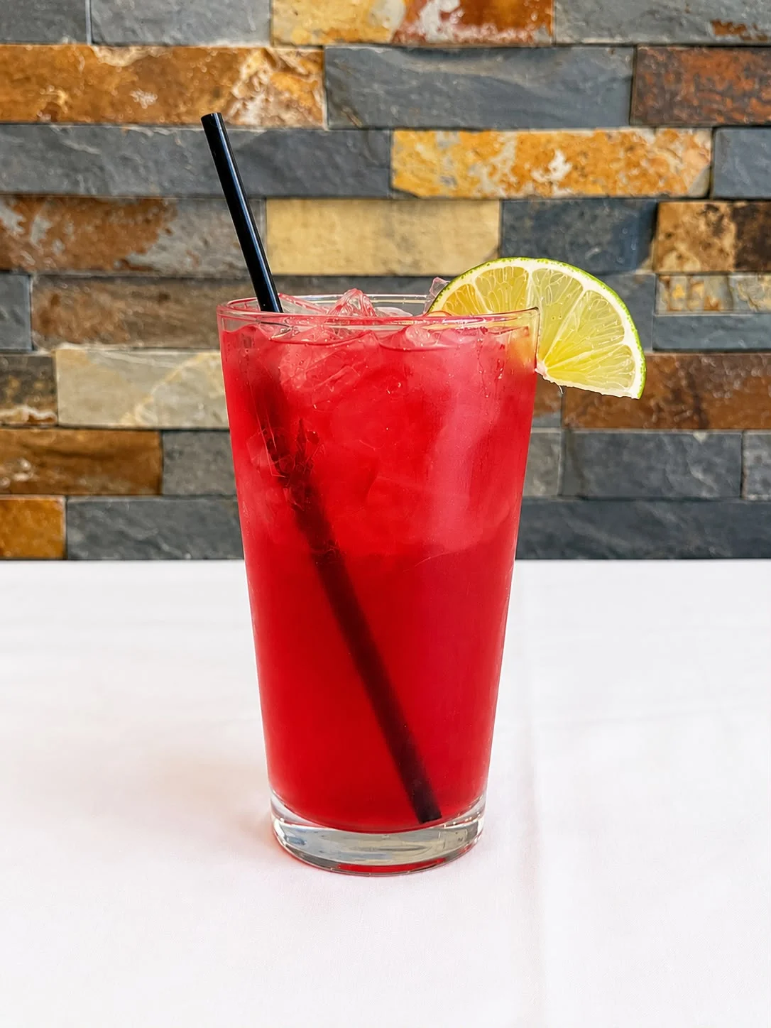 Refreshing cocktail with lime garnish on a restaurant table