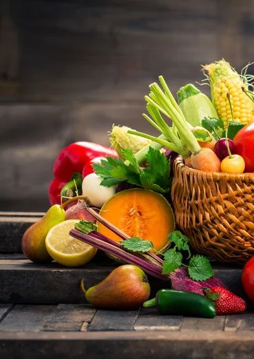 Colorful basket of fresh seasonal fruits and vegetables