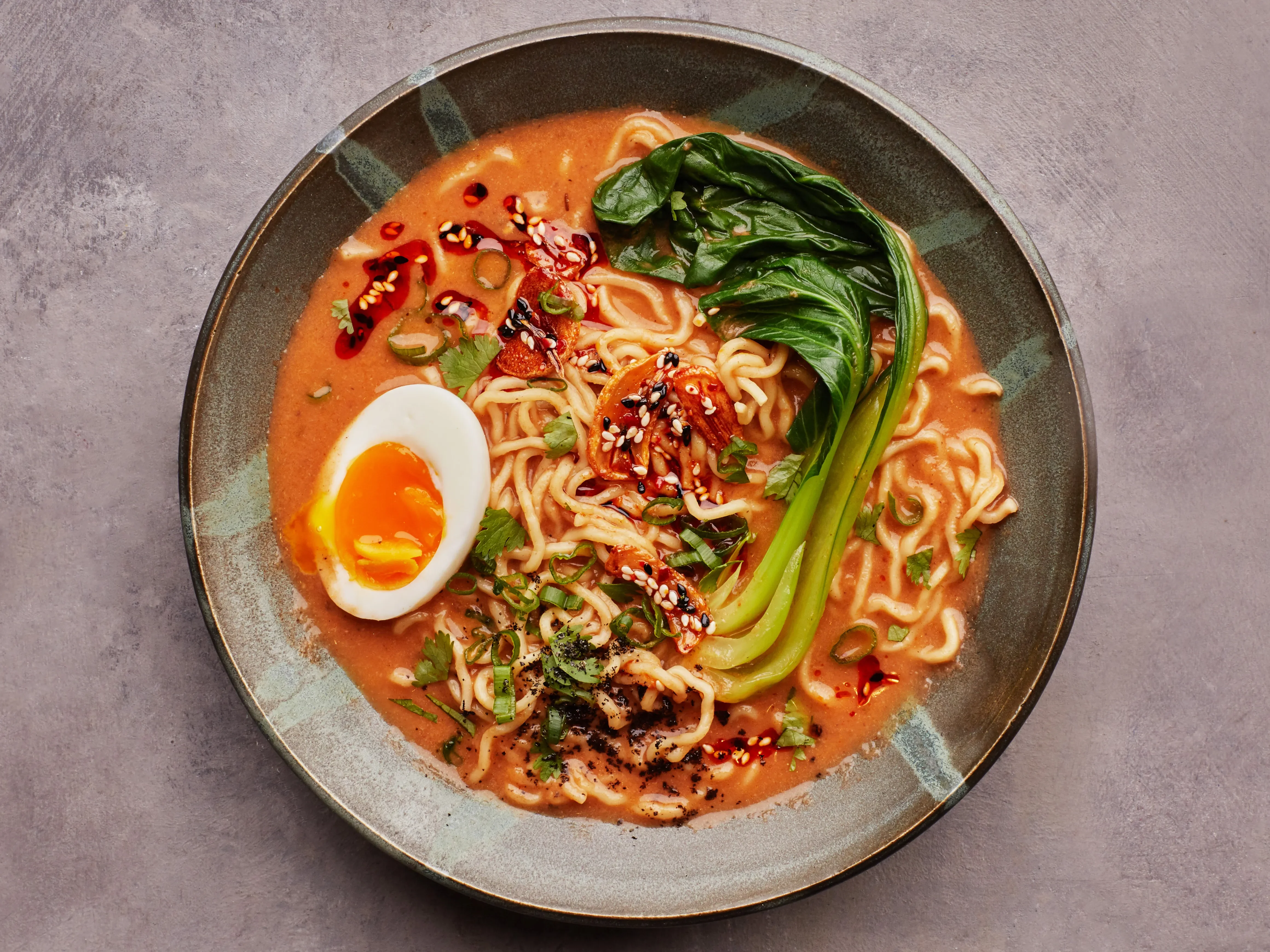 Creamy Japanese ramen with soft-boiled egg and greens