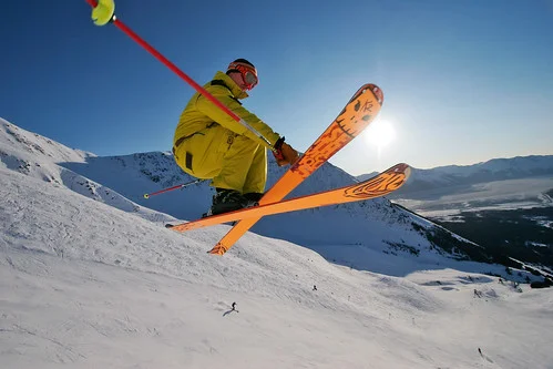 Skier performing a jump on a snowy mountain slope