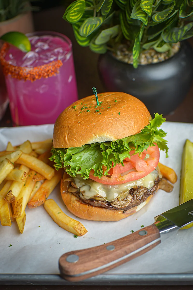 Juicy cheeseburger with fries and a refreshing cocktail