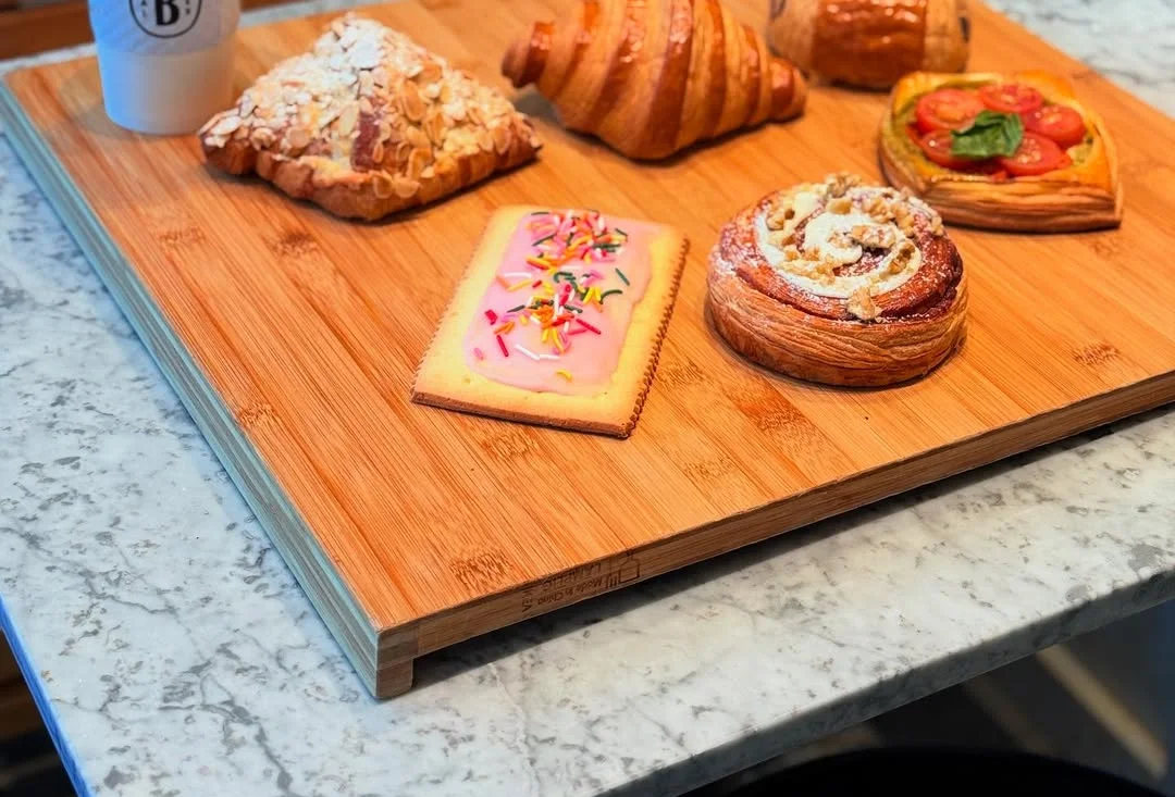 Assorted pastries and coffee on a wooden board