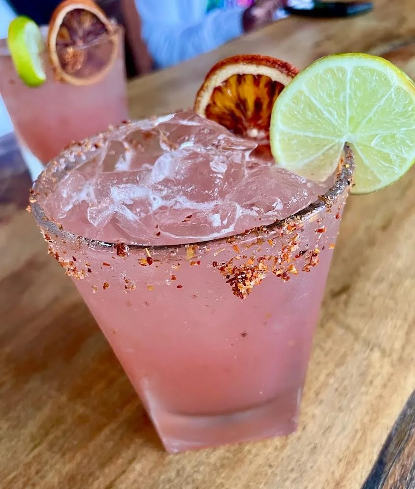 Refreshing pink margarita with lime and dried orange garnish