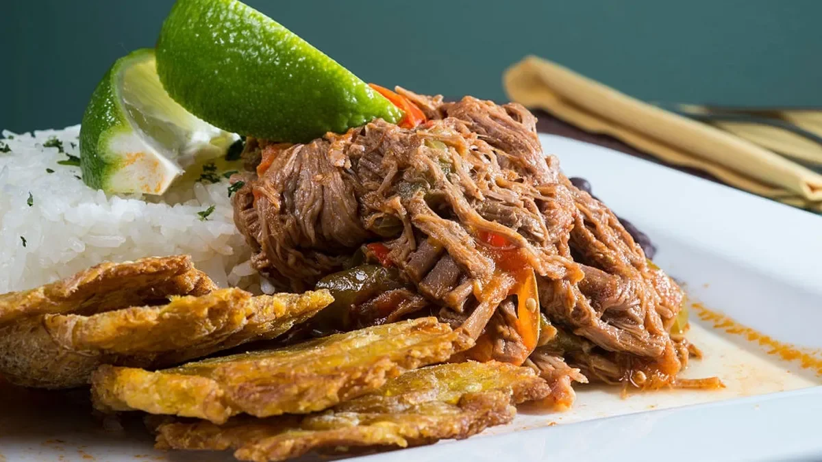 Cuban ropa vieja served with rice and tostones