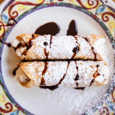 Delicious Italian cannoli drizzled with chocolate sauce