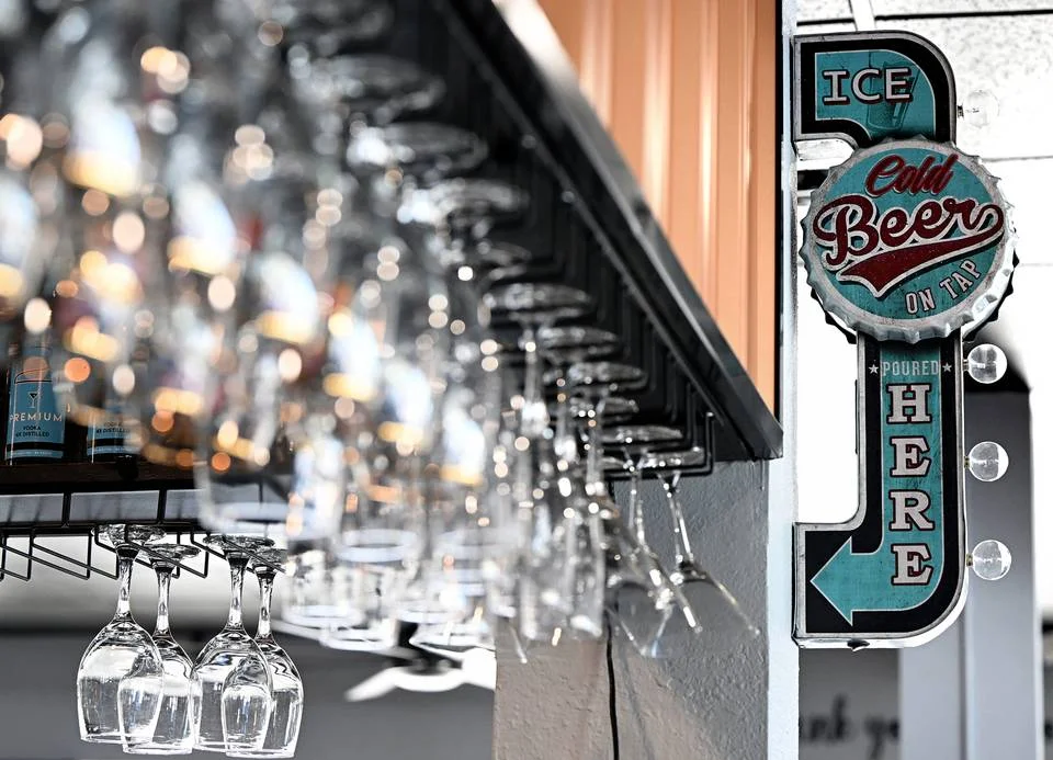 Bar with hanging glasses and a vintage beer sign