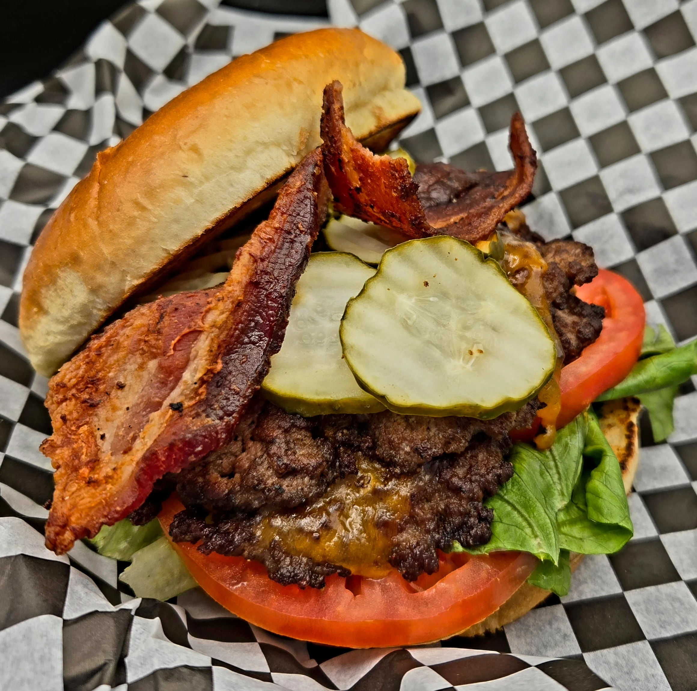 Delicious gourmet burger with fresh toppings on a wooden table
