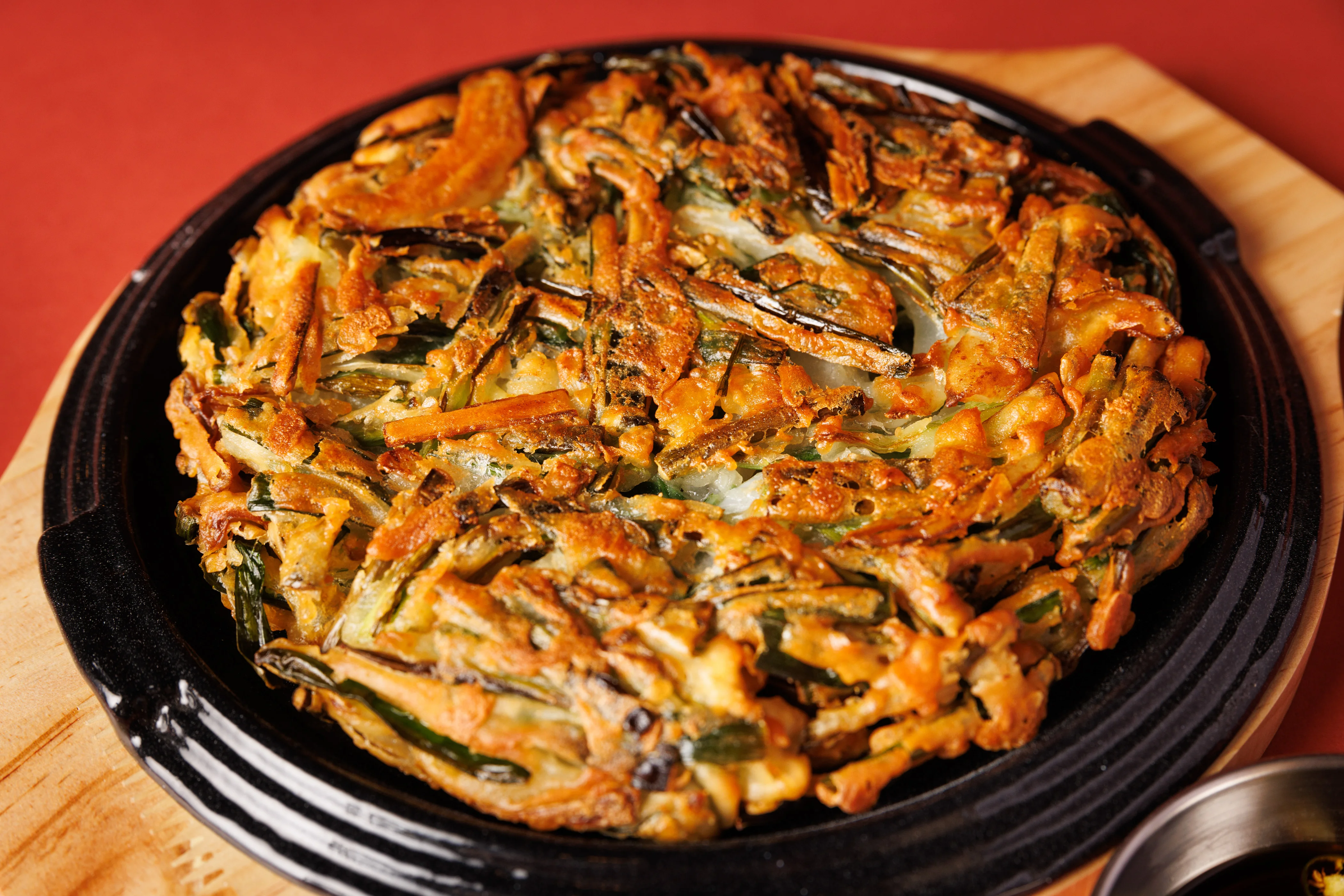 Korean vegetable jeon served on a sizzling plate