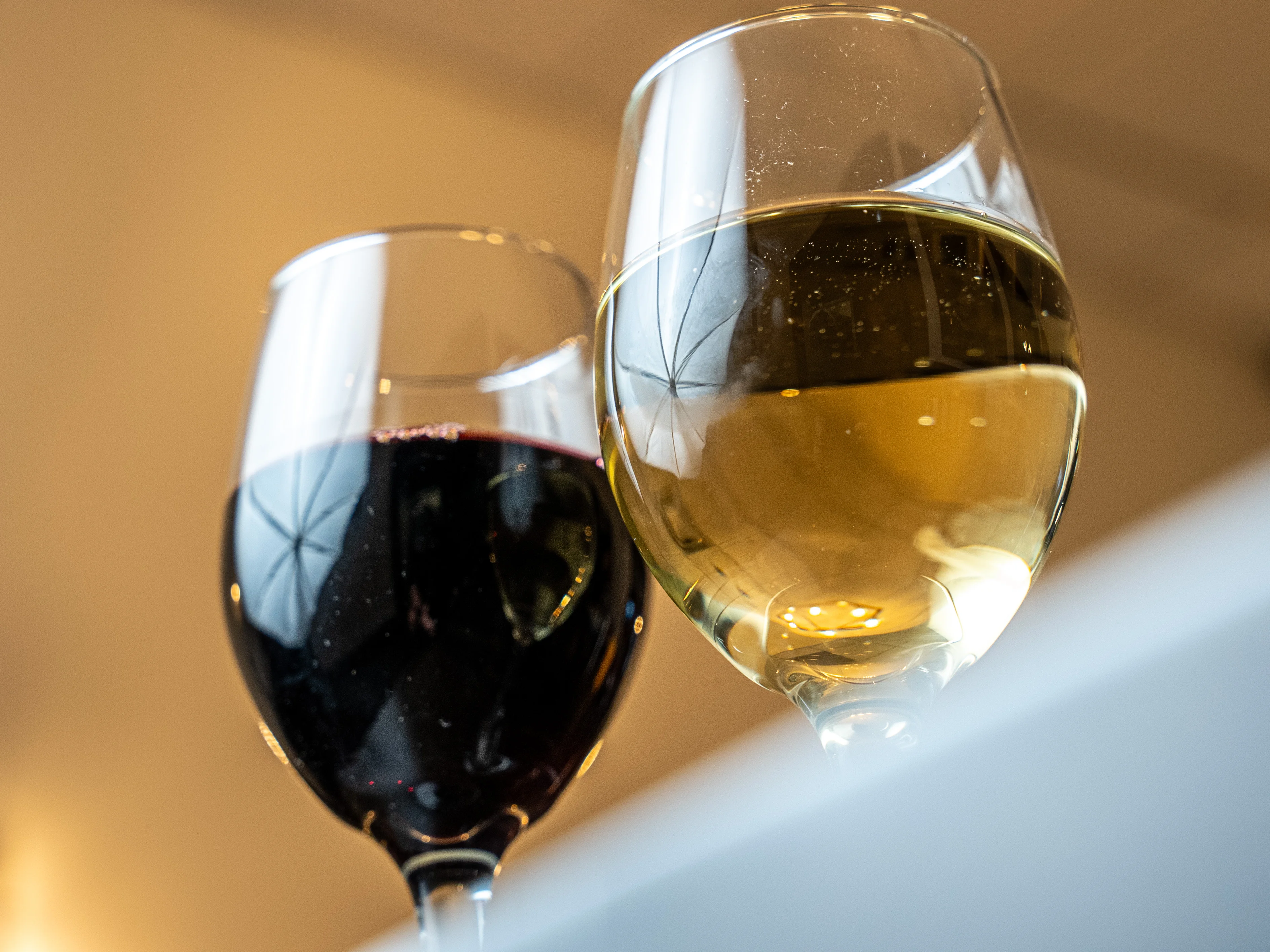 Red and white wine glasses clinking together in celebration